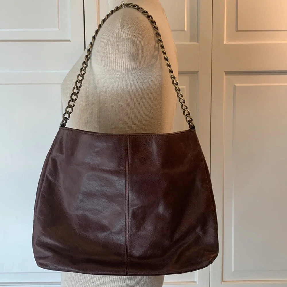 Hobo brown leather purse with bow on front and brass looking chain strap